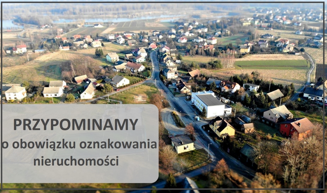 napis: przypominamy o obowiązku oznakowania nieruchomości, w tle zdjęcie wsi Wilczkowice wykonane z dronem